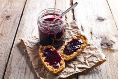 jar of grape jelly with two slices of homemade bread