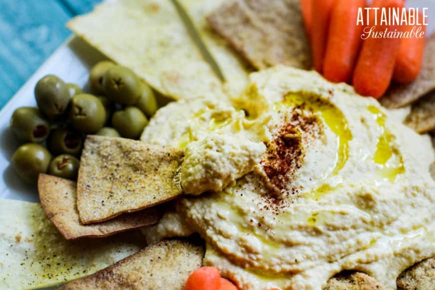 easy homemade hummus on a platter, chip and hummus in foreground