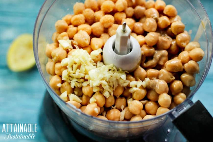 garbanzo beans and garlic in the bowl of a food process to make easy homemade hummus.