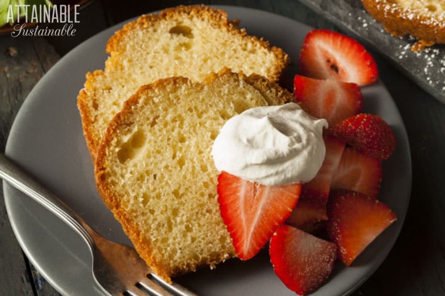 passion fruit cake slices on a plate with strawberries and whipped cream