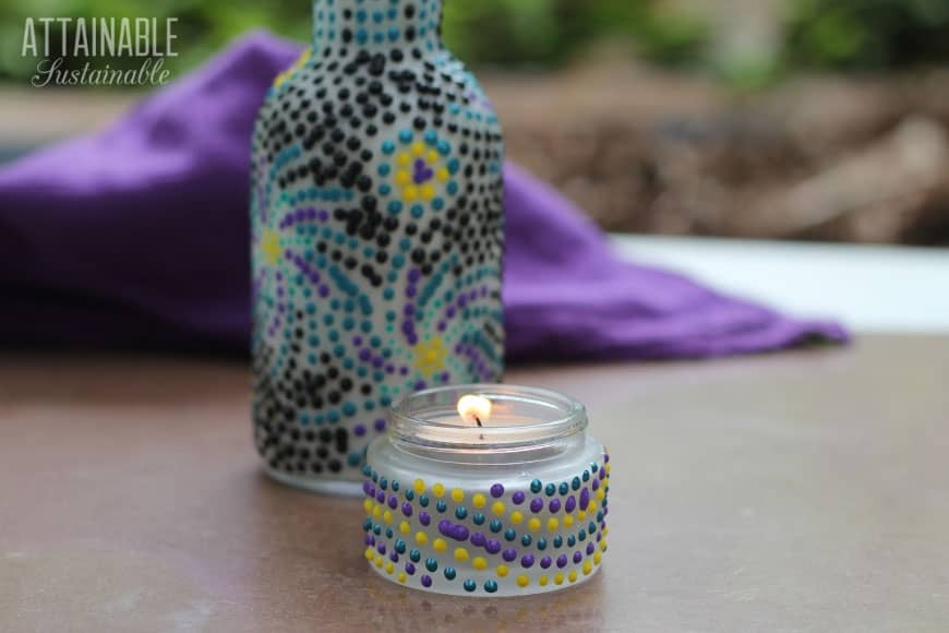 decorating glass jars and bottles with dots of paint to make DIY candle holders