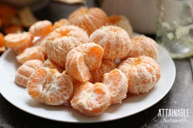white plate full of peeled tangerines.
