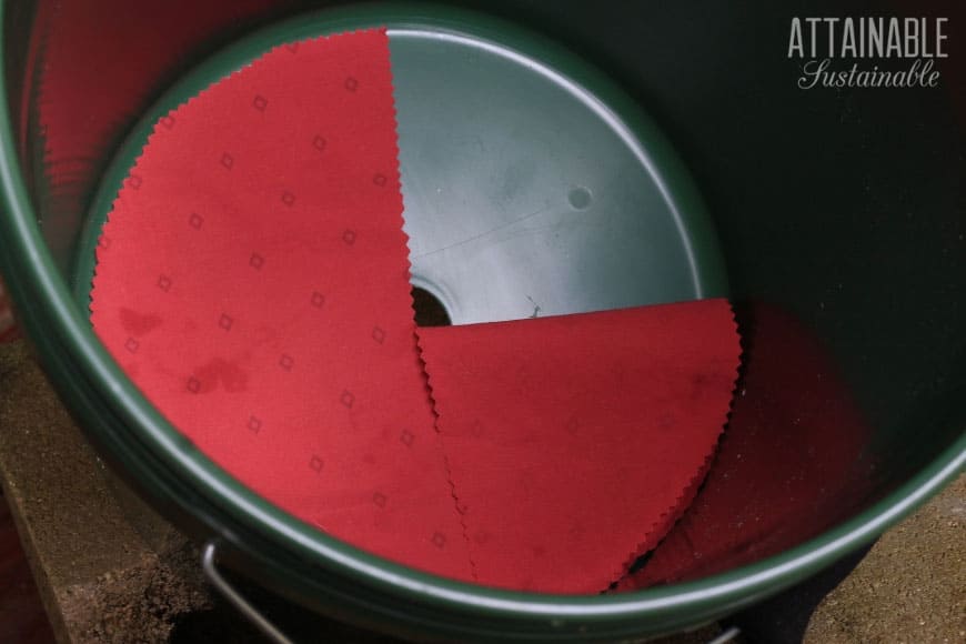 round piece of red fabric in the bottom of a bucket 