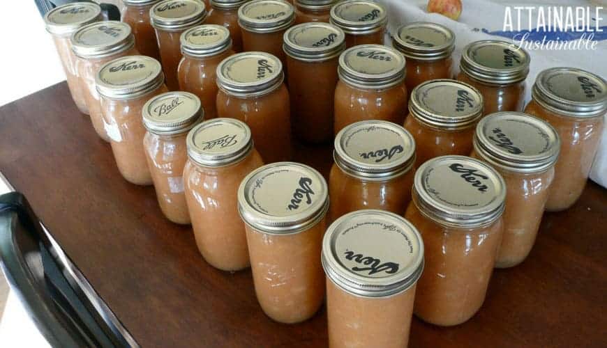 jars of applesauce on a wooden table ready for canning storage