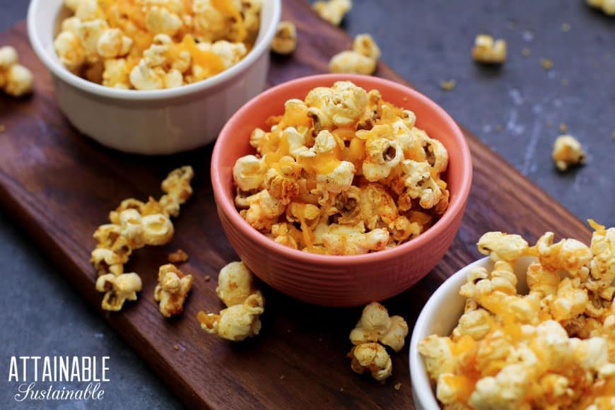 cheddar popcorn snacks in several bowls (on brown board)