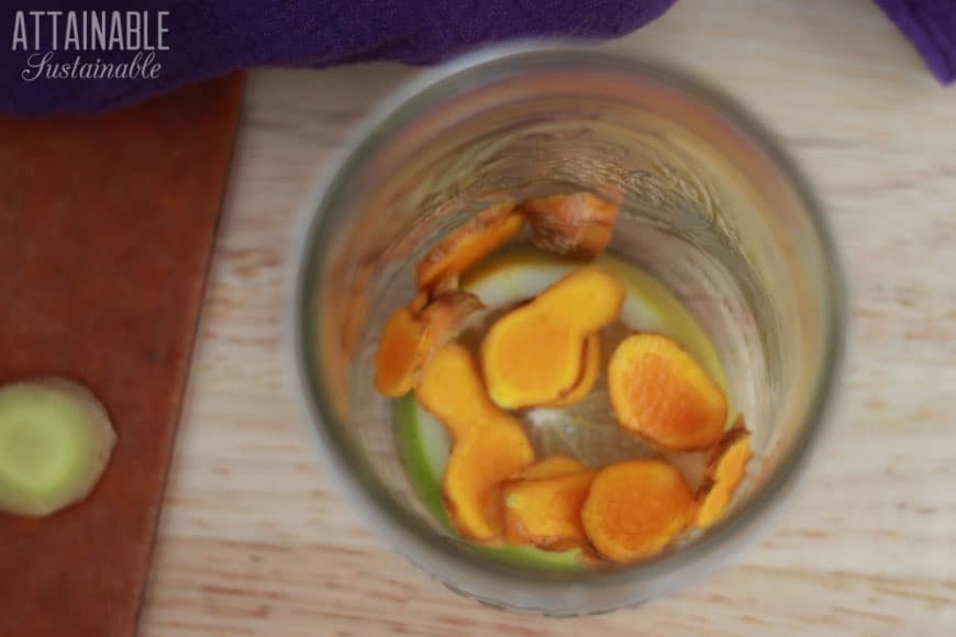 sliced turmeric in the bottom of a glass jar