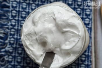 homemade marshmallow fluff in a jar from above, blue and white cloth behind