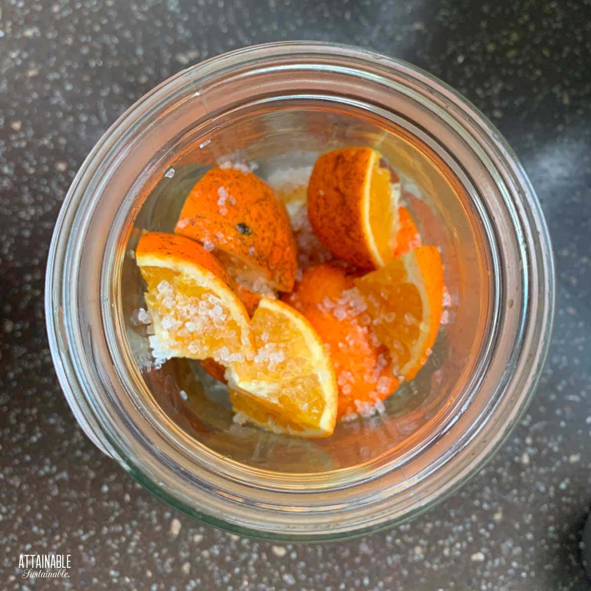 pieces of orange inside a glass jar from above.
