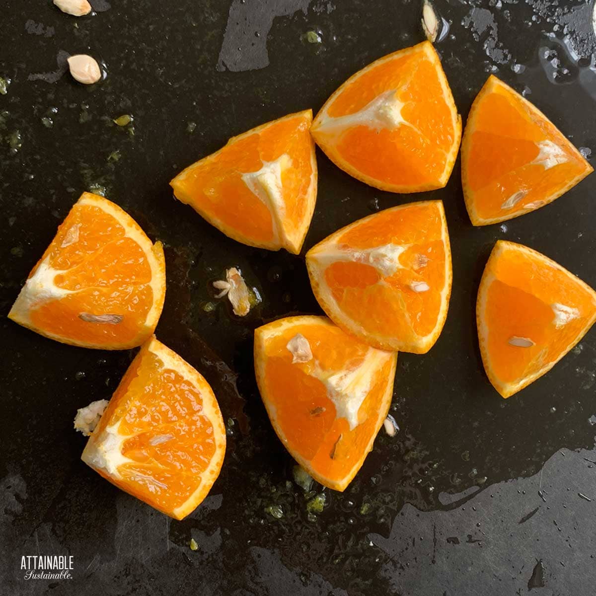 Fresh orange, cut into 8 triangle wedges on a black background.