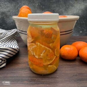 quart jar full of oranges covered in liquid.