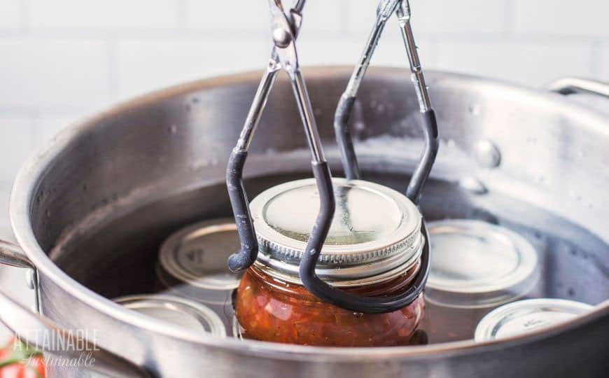 jar lifter putting jar of salsa into canner