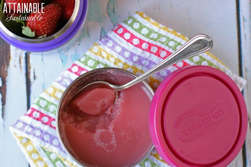 homemade jello (pink) in a stainless container, and a spoonful of jello scooped up