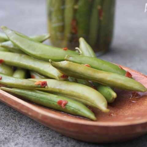 fermented snap peas in a wooden dish