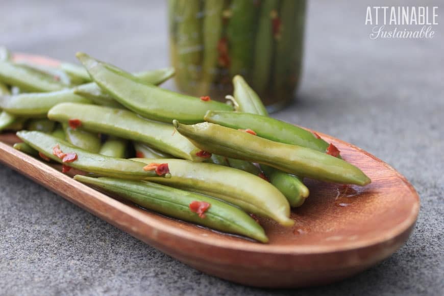 fermented sugar snap peas in a long wooden dish