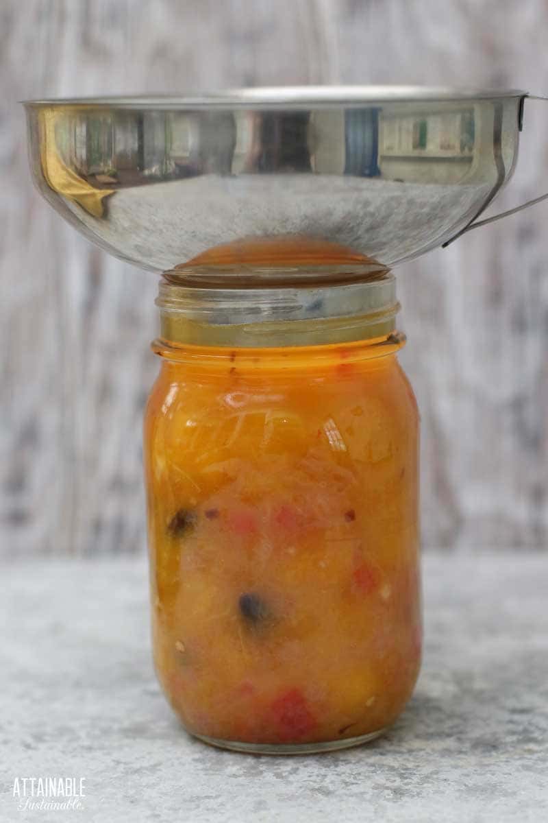 canning funnel on a jar filled with chutney.