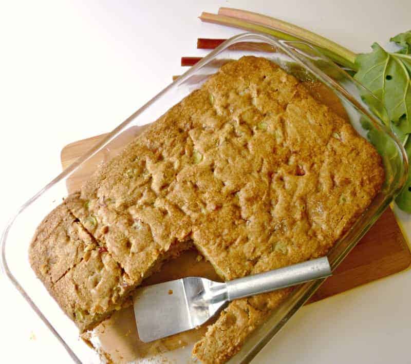 rhubarb cake in glass pan with metal spatula