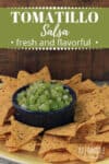 tomatillo salsa in a blue bowl surrounded by tortilla chips