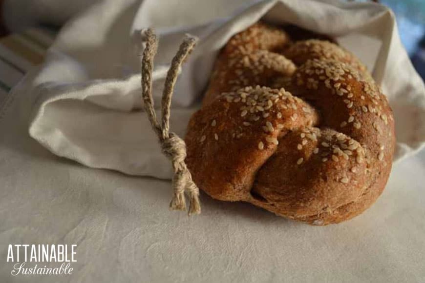 loaf of braided bread in a linen bread bag