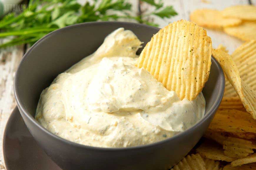 dip with ruffled chips in a brown bowl