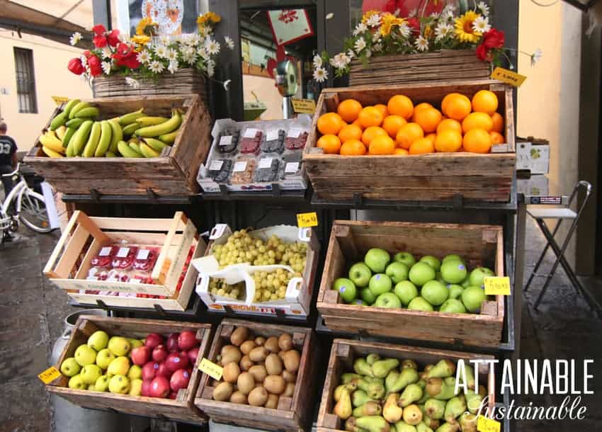 fresh fruit stand with bananas, oranges, apples, and pears in wooden boxes