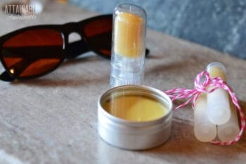 homemade sunscreen in a silver tin with sunglasses