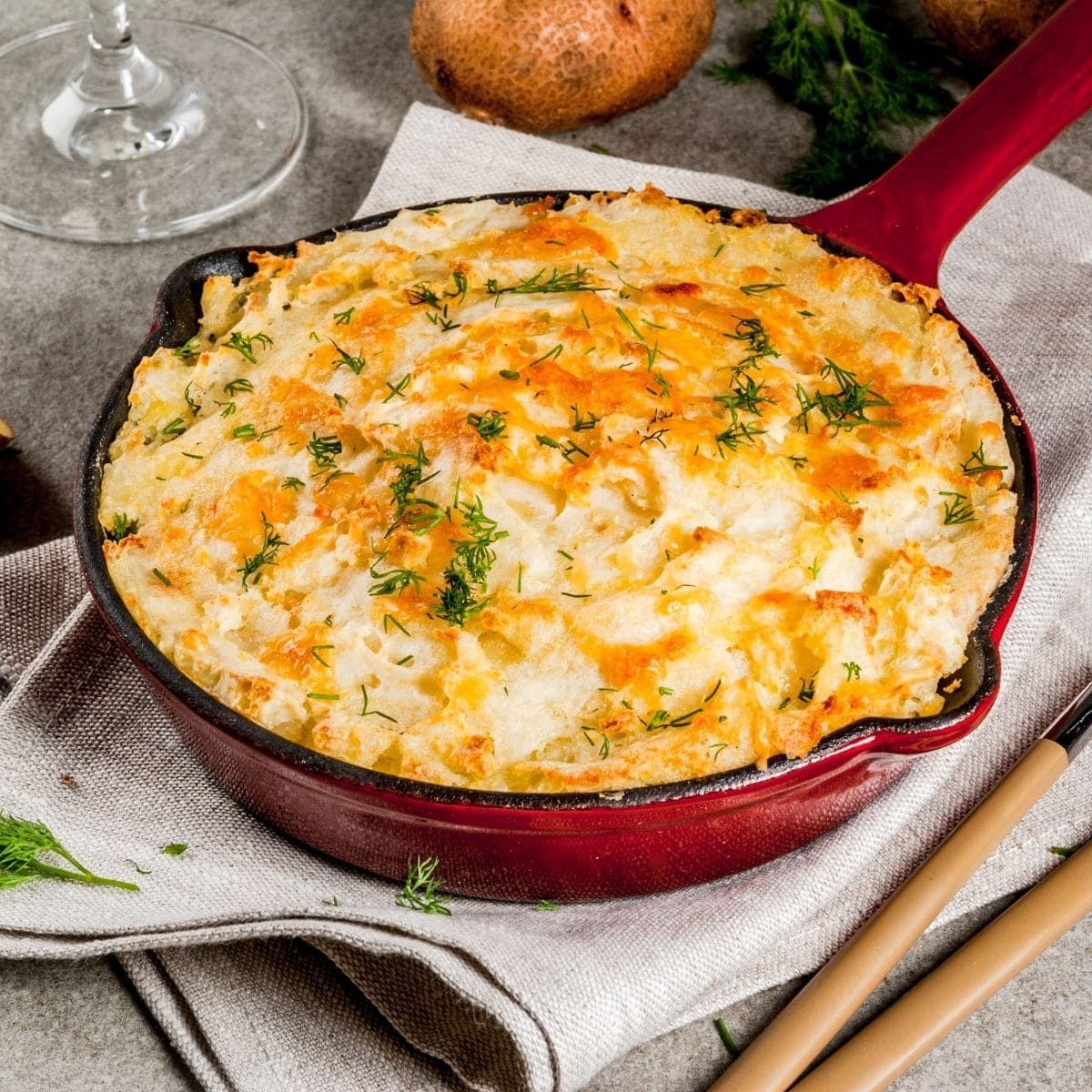 mashed potato casserole in a red cast iron pan.