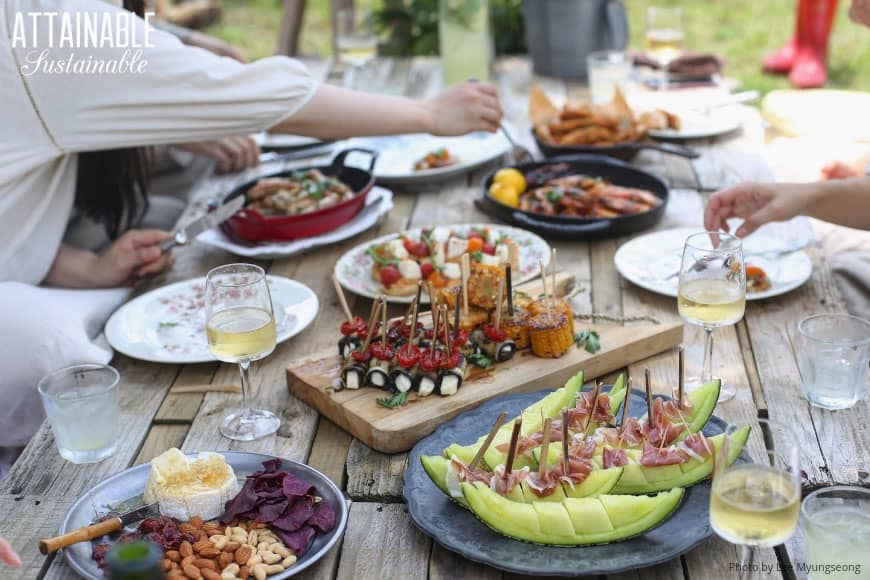 outdoor gathering with food on a wooden table