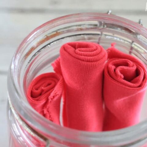homemade dryer sheets (pink) in a glass jar