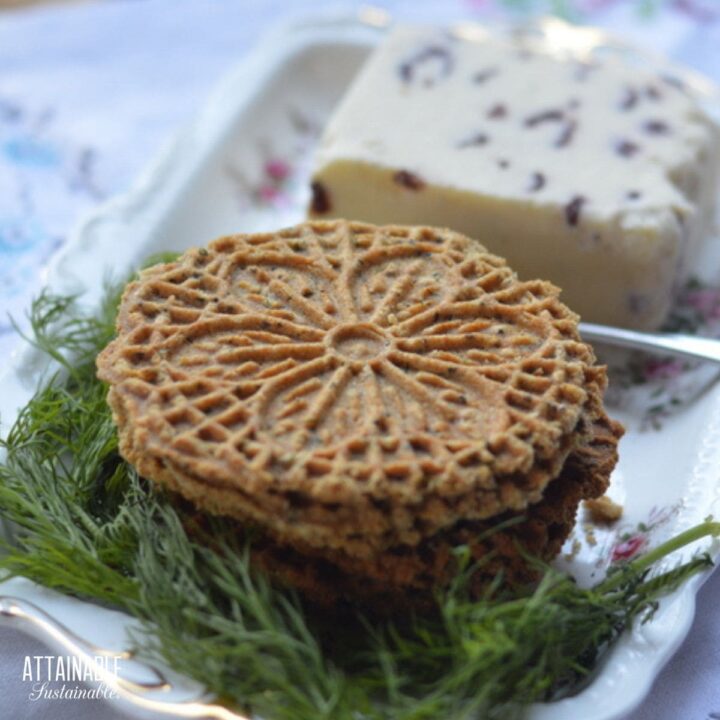 pizzelle crackers on a plate with fresh dill and cheese.