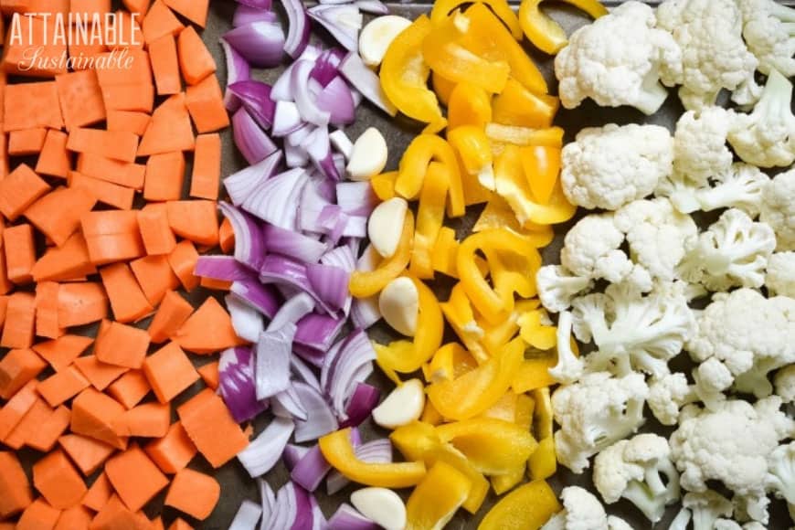 vegetables ready to roast on a baking tray: carrots, red onions, yellow bell pepper, cauliflower