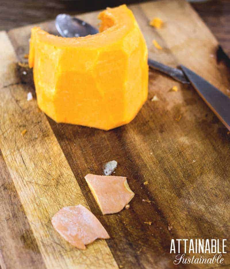 peeled raw pumpkin on a cutting board with a knife