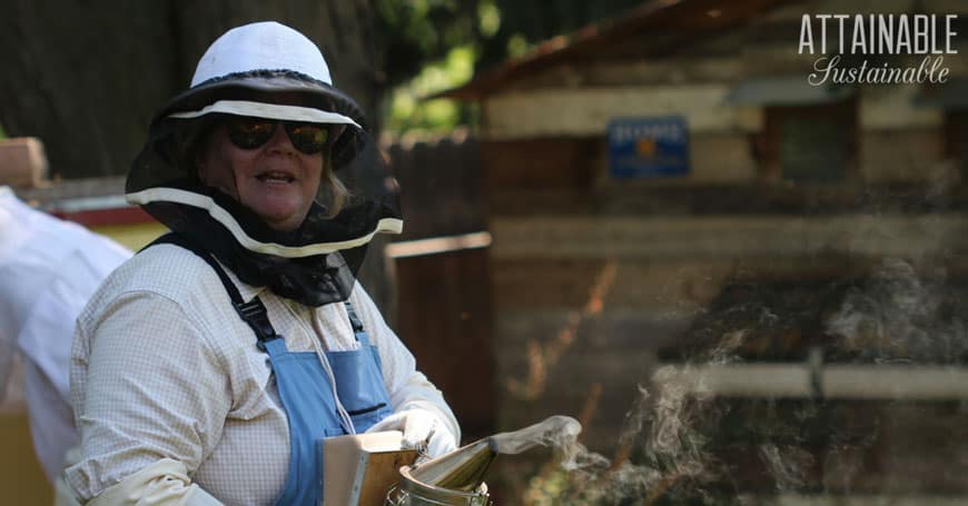 woman in beekeeping gear doing fall chores