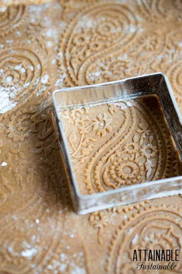 cutting ginger cookie dough into squares with a cookie cutter