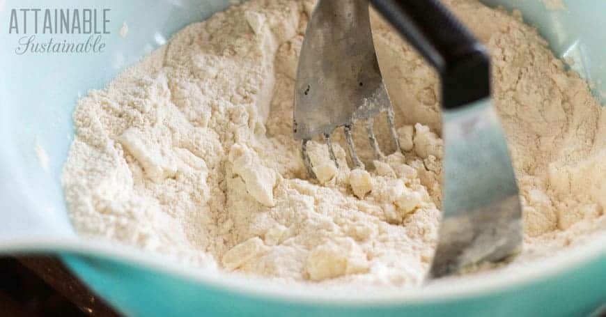 dry ingredients in a teal bowl with pastry blender