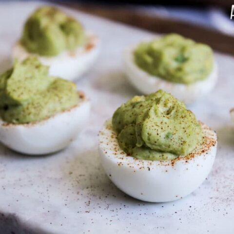 Deviled eggs with green avocado filling
