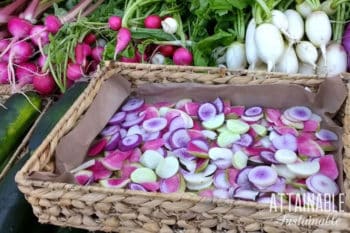 colorful red, pink, and purple radishes in a flat rectangular basket