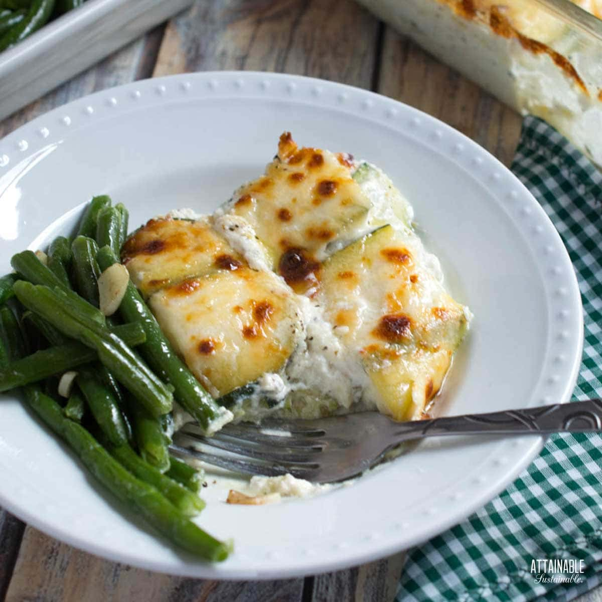 zucchini lasagna on a plate with green beans.