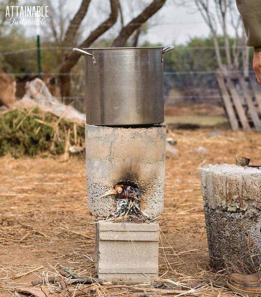 concrete rocket stove with large pot on top used as cooking tool for living off the grid