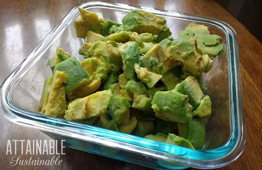 frozen avocados in a glass freezer storage container