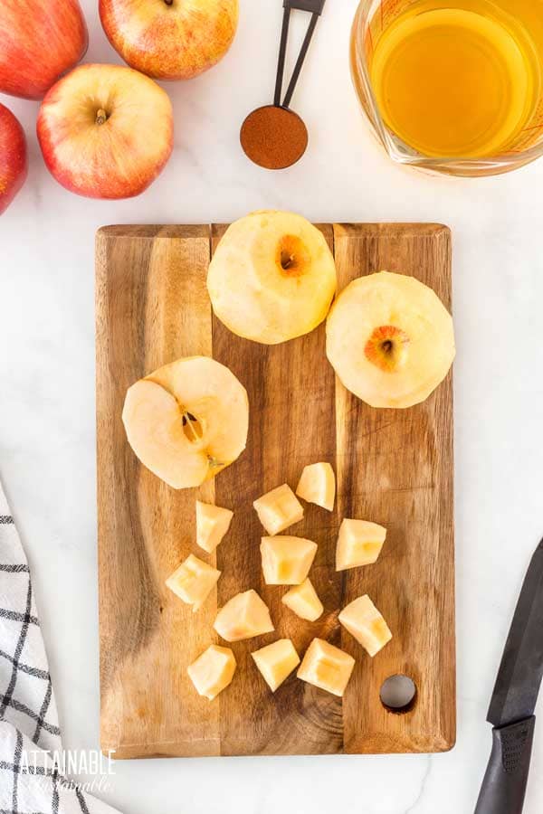 peeled, halved, and chunked apples on a cutting board.