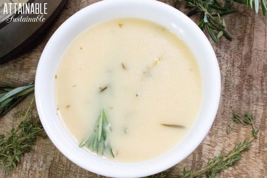 turkey gravy in a white bowl with herbs