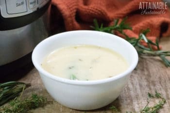 turkey gravy in a white bowl with herbs