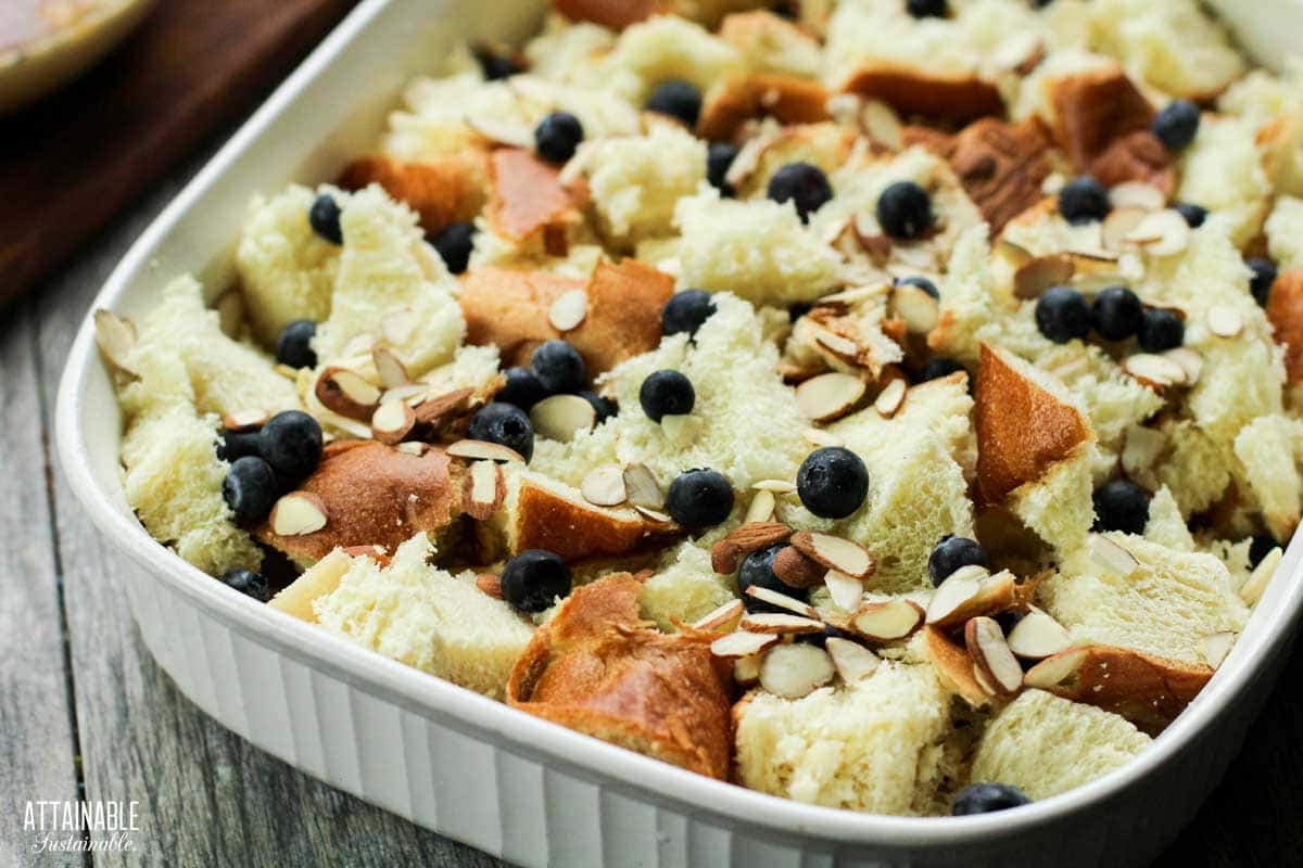 uncooked french toast casserole with blueberries and sliced almonds on top.