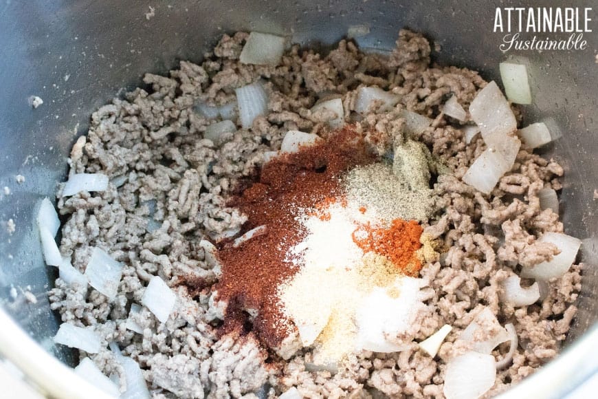 browned ground beef in instant pot with seasonings for chili