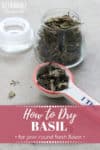 dried basil in a ceramic tablespoon measure, with more in a glass jar with words: how to dry basil in pink.