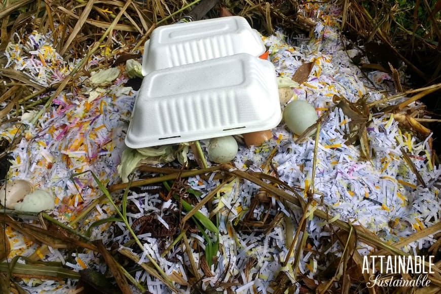 shredded paper and paperboard takeout container in a compost pile