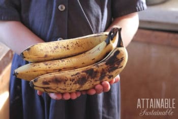 girl in blue dress holding overripe bananas