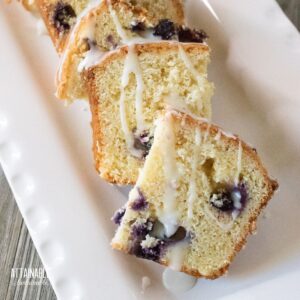 slices of lemon blueberry loaf cake on a white dish.