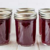 jars of grape jelly with lids in a row