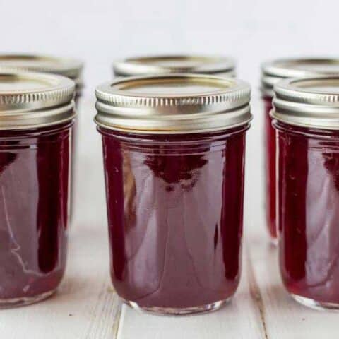 jars of grape jelly with lids in a row